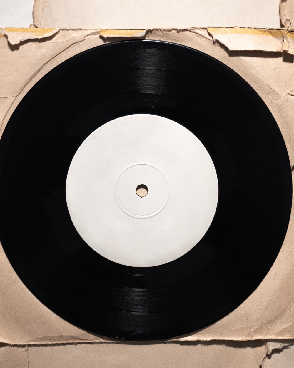 a white-label acetate disc in a worn paper sleeve